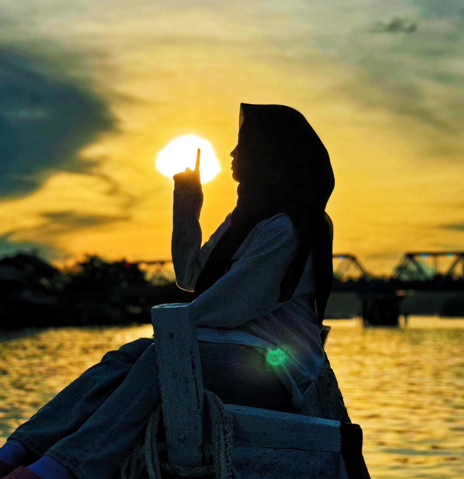 Aerial view of meandering river through traditional Indonesian riverside village with wooden houses on stilts and lush green forest landscape in Berau regency